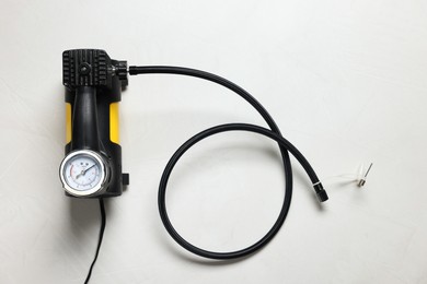 Photo of One modern tire inflator on light background, top view