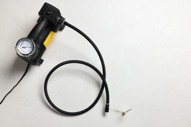 Photo of One tire inflator on light background, top view. Space for text