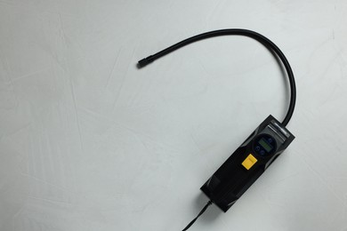 Photo of One tire inflator on light background, top view. Space for text