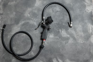 Photo of One tire inflation gun with gauge on grey background, top view