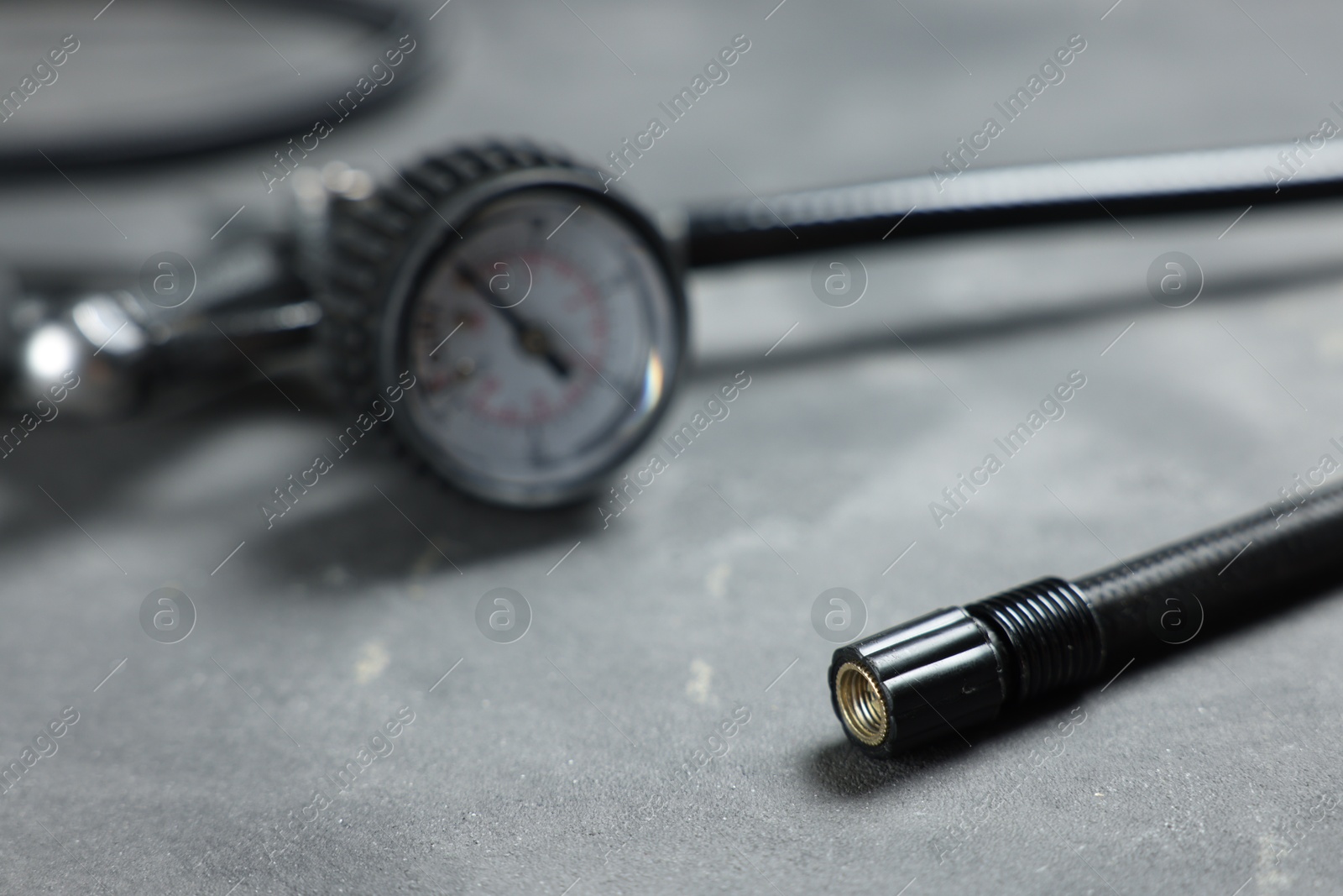 One tire inflation gun with gauge on grey background, closeup Photo of One tire inflation gun with gauge on grey background, closeup