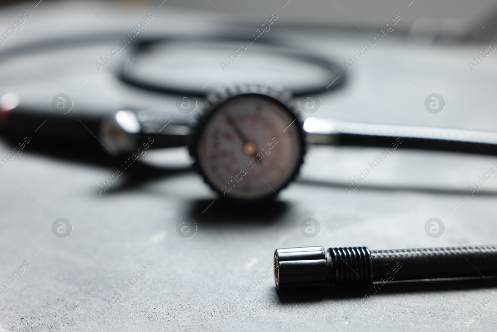 One tire inflation gun with gauge on grey background, closeup Photo of One tire inflation gun with gauge on grey background, closeup
