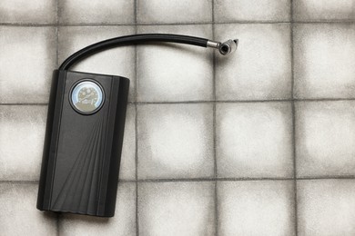 Photo of One tire inflator on light tiled background, top view. Space for text
