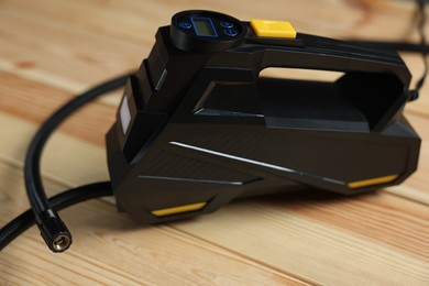Photo of One modern tire inflator on wooden background, closeup