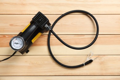 Photo of One modern tire inflator on wooden background, top view