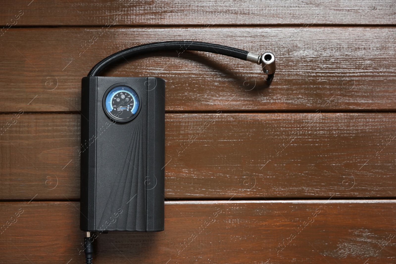 Photo of One tire inflator on wooden background, top view. Space for text