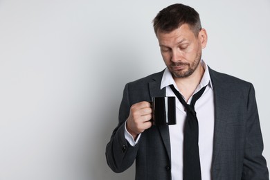 Photo of Man with cup of drink suffering from hangover on white background, space for text