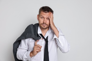 Photo of Man suffering from hangover on white background