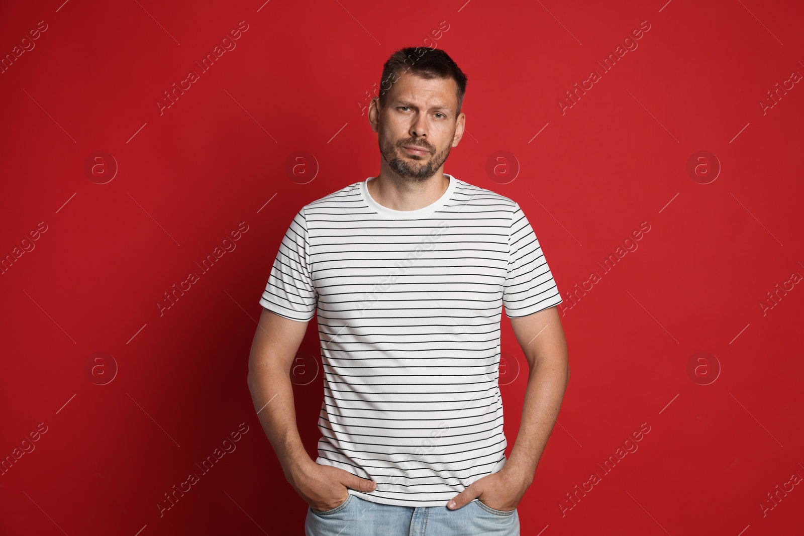 Man suffering from hangover on red background Photo of Man suffering from hangover on red background