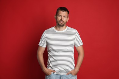 Photo of Man suffering from hangover on red background