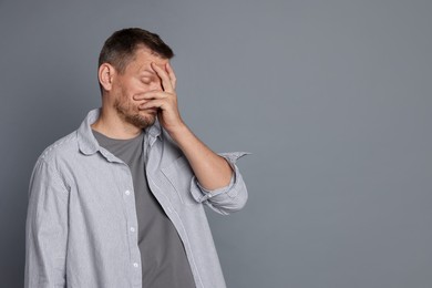 Photo of Man suffering from hangover on grey background, space for text