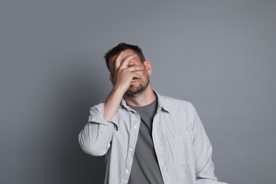 Photo of Man suffering from hangover on grey background