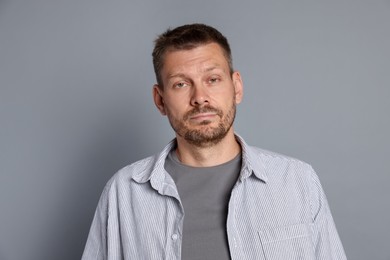 Photo of Man suffering from hangover on grey background