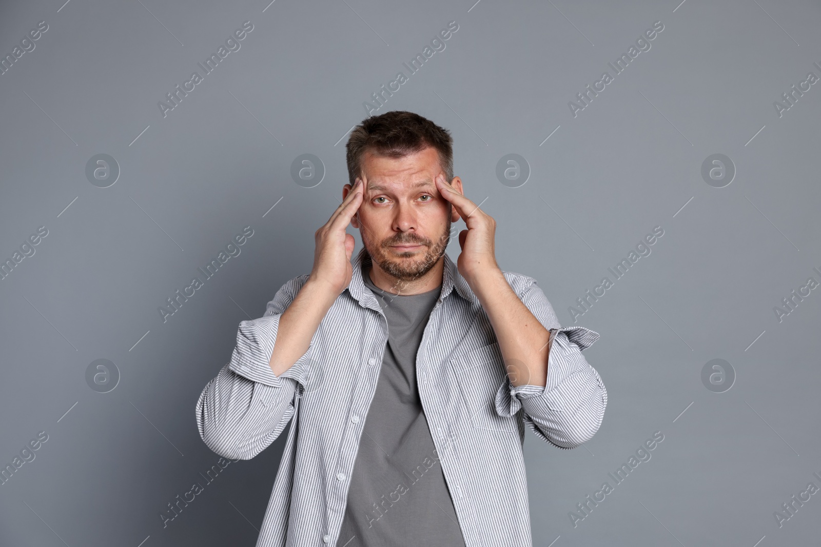Photo of Man suffering from hangover on grey background
