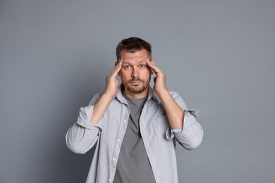 Photo of Man suffering from hangover on grey background