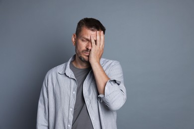 Photo of Man suffering from hangover on grey background, space for text