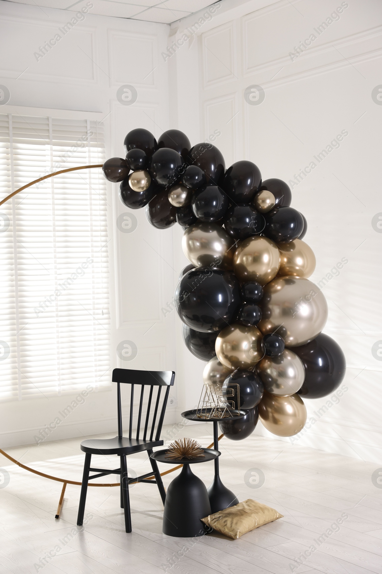 Photo of Stylish photo zone with balloons, chair and decor in studio