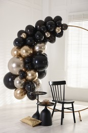 Photo of Stylish photo zone with balloons, chair and decor in studio