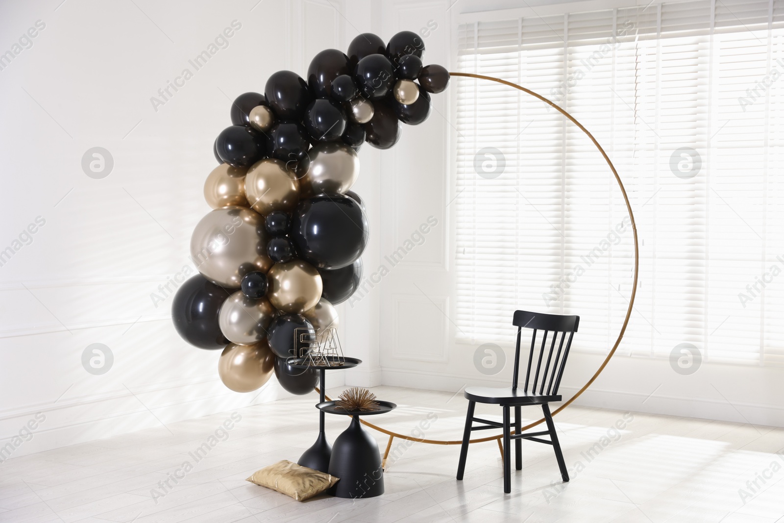 Photo of Stylish photo zone with balloons, chair and decor in studio