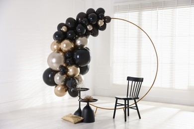 Photo of Stylish photo zone with balloons, chair and decor in studio