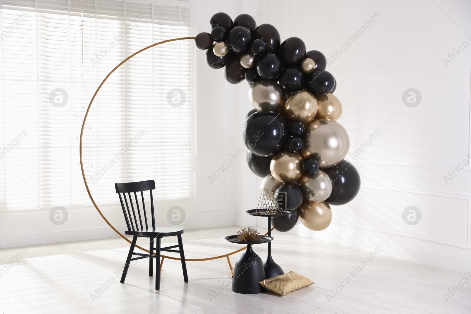 Stylish photo zone with balloons, chair and decor in studio Photo of Stylish photo zone with balloons, chair and decor in studio