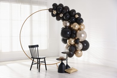 Photo of Stylish photo zone with balloons, chair and decor in studio