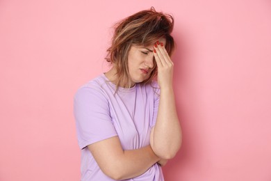 Photo of Woman suffering from hangover on pink background
