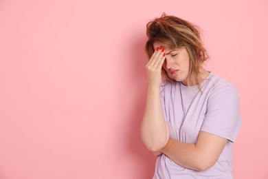 Photo of Woman suffering from hangover on pink background. Space for text