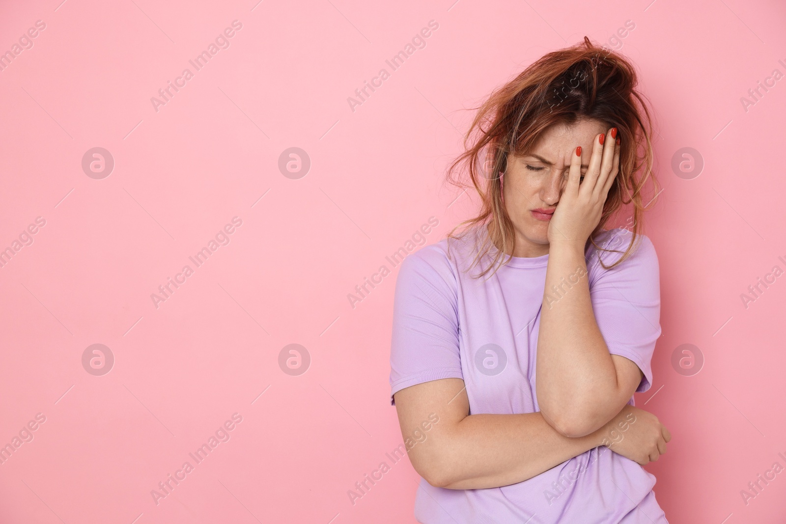 Photo of Woman suffering from hangover on pink background. Space for text