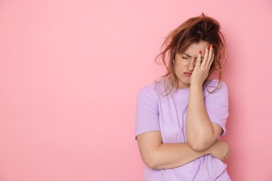 Photo of Woman suffering from hangover on pink background. Space for text