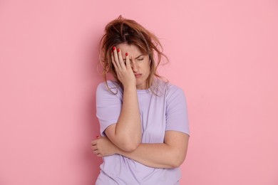 Photo of Woman suffering from hangover on pink background