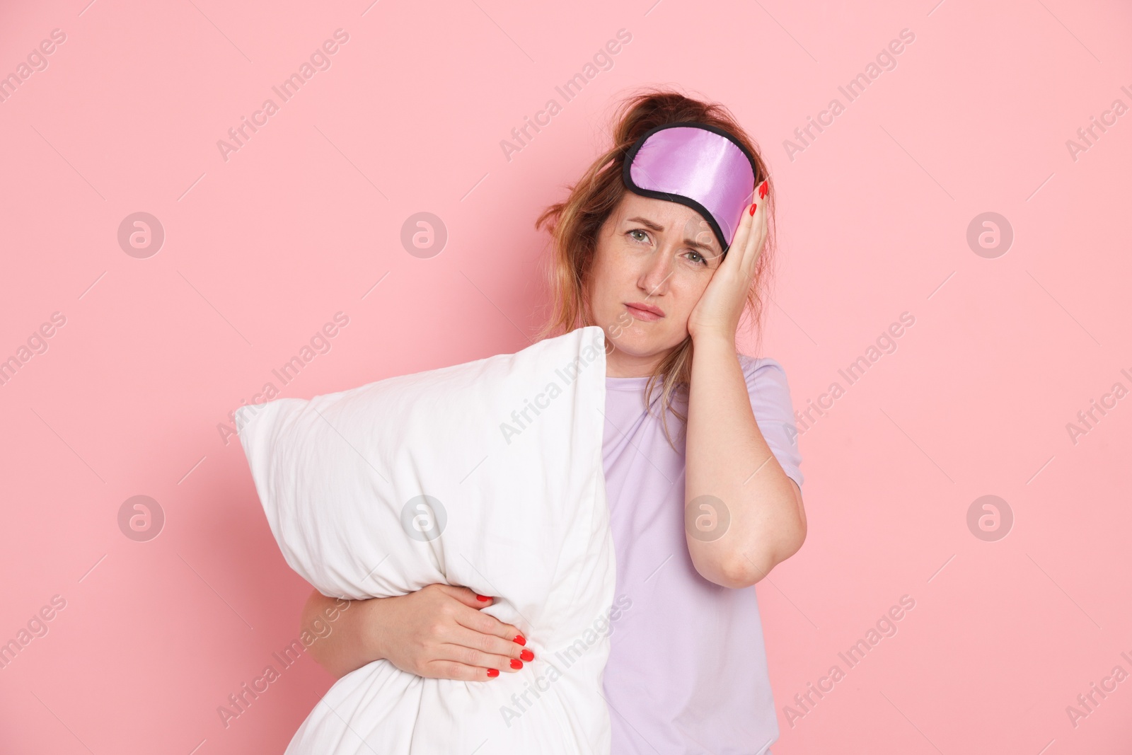 Woman with pillow suffering from hangover on pink background Photo of Woman with pillow suffering from hangover on pink background