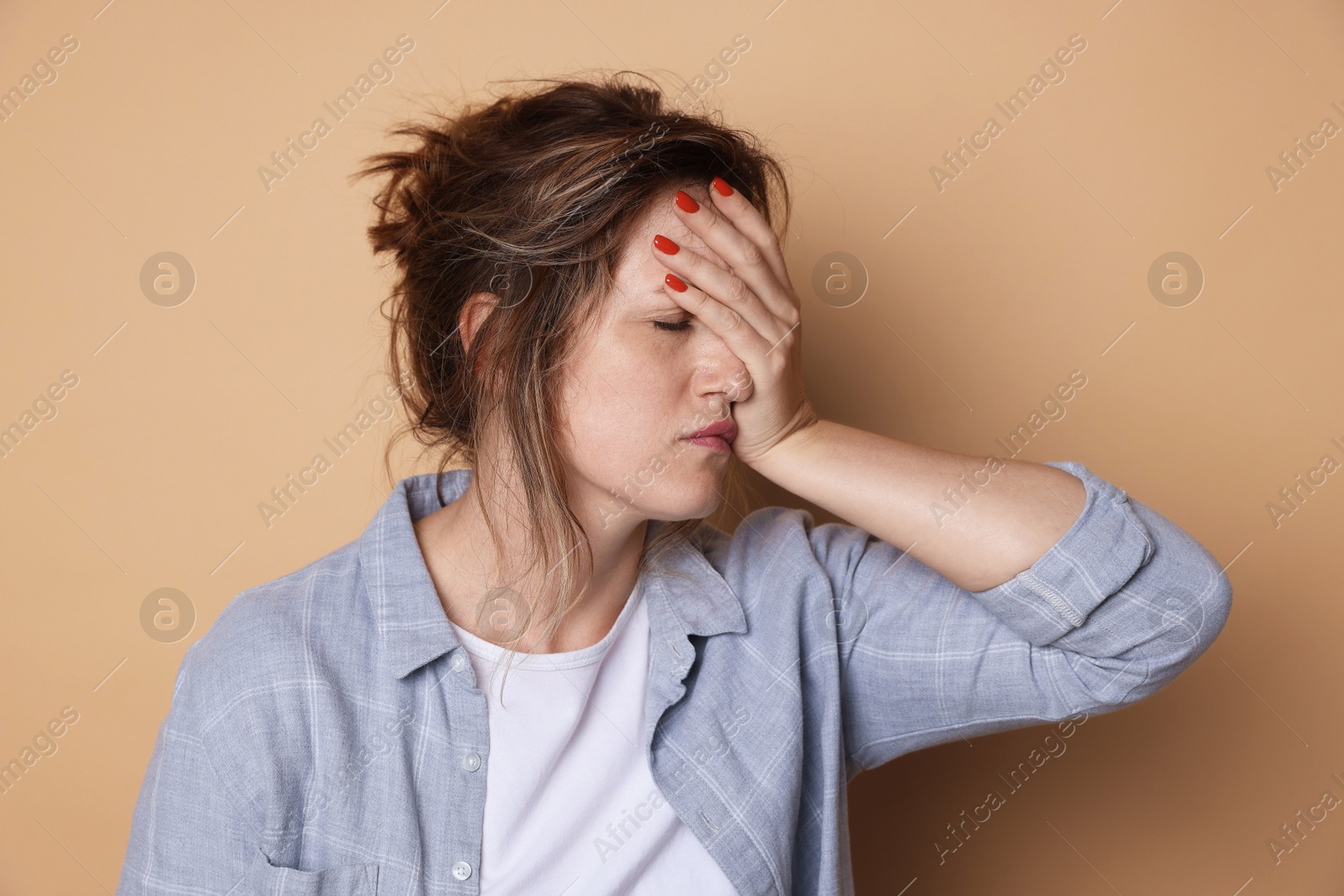 Woman suffering from hangover on beige background Photo of Woman suffering from hangover on beige background