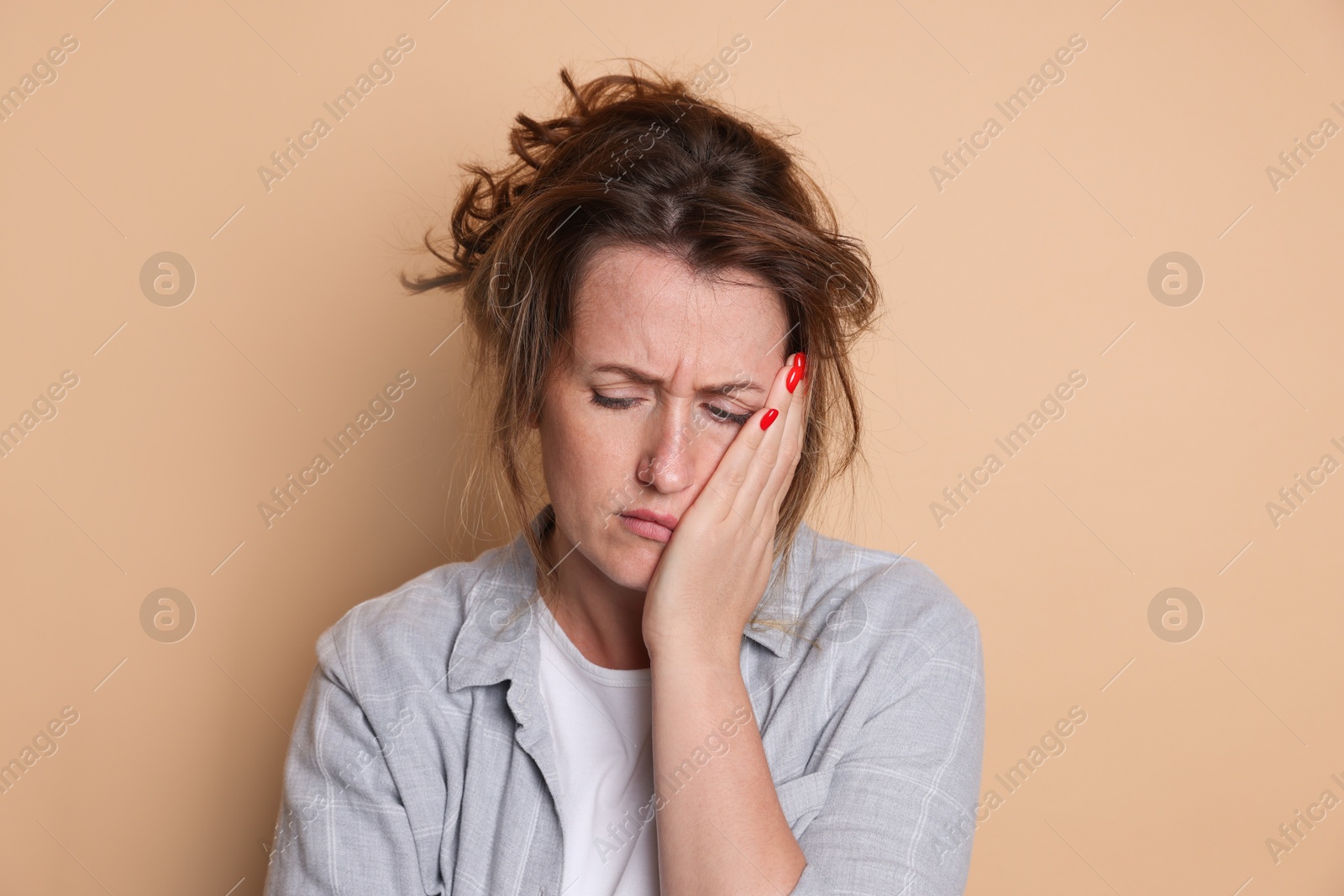 Woman suffering from hangover on beige background Photo of Woman suffering from hangover on beige background