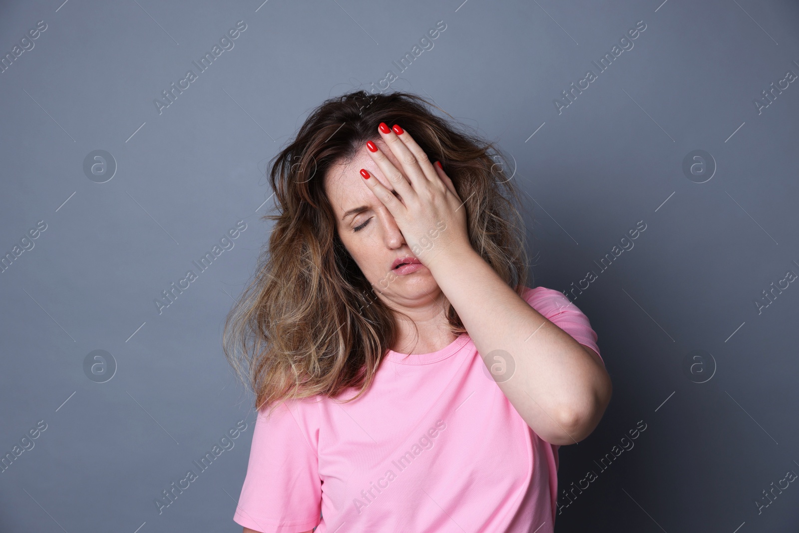 Photo of Woman suffering from hangover on grey background