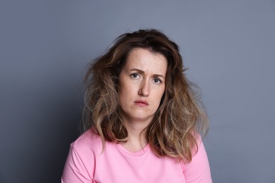 Photo of Woman suffering from hangover on grey background