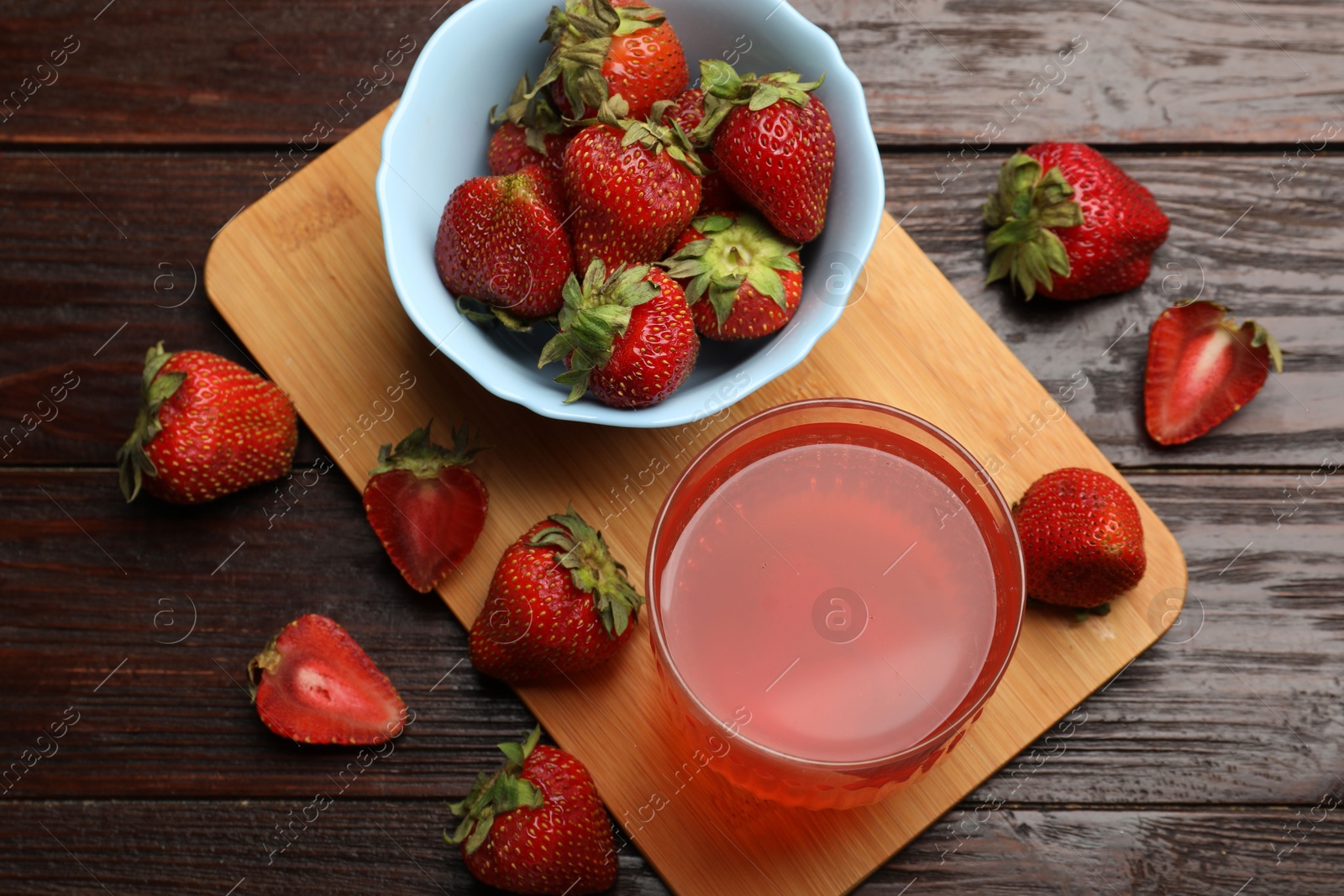 Photo of Tasty compot and strawberries on wooden table, flat lay