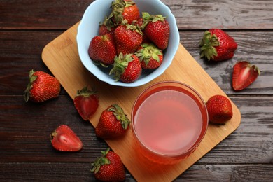 Photo of Tasty compot and strawberries on wooden table, flat lay