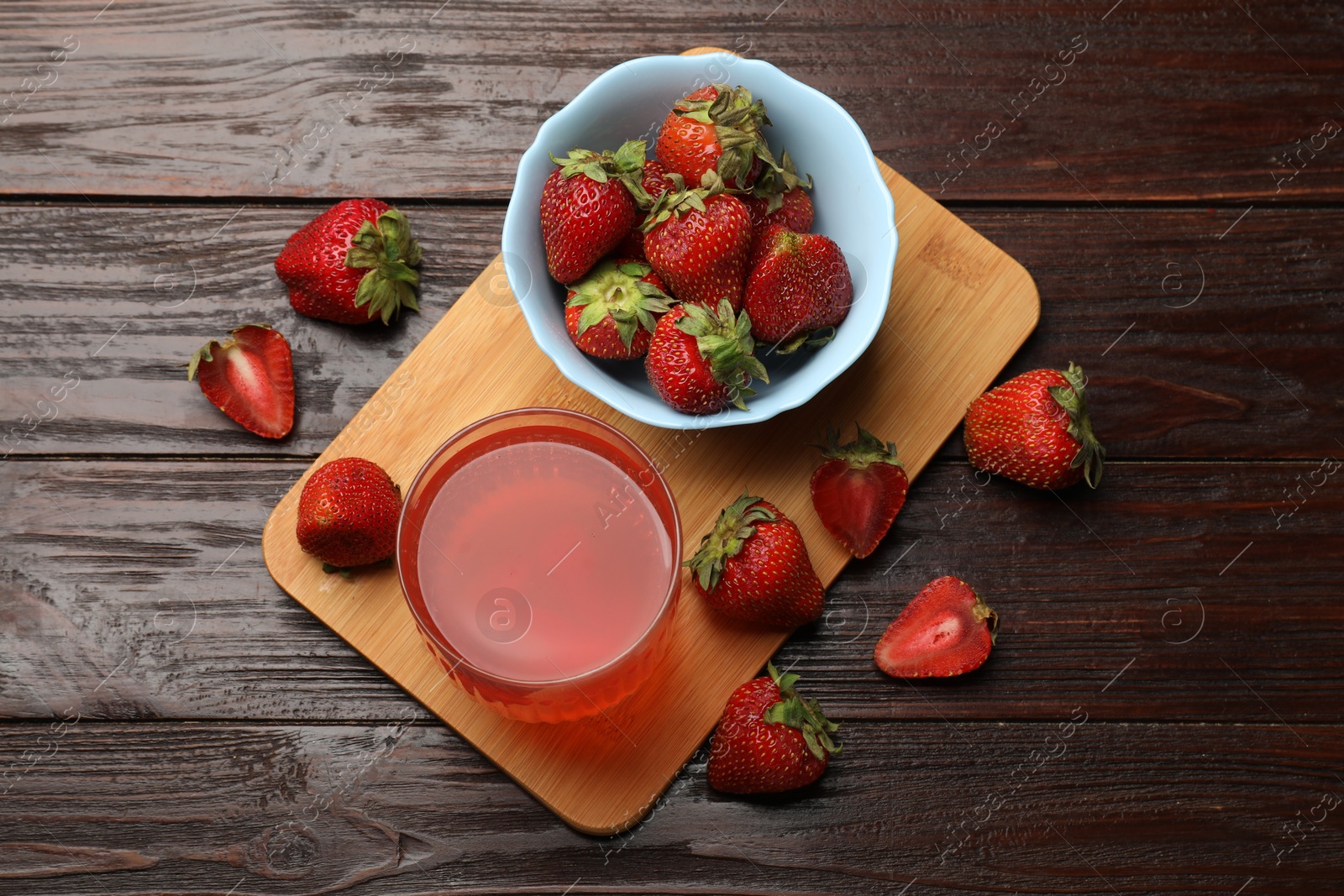 Photo of Tasty compot and strawberries on wooden table, flat lay