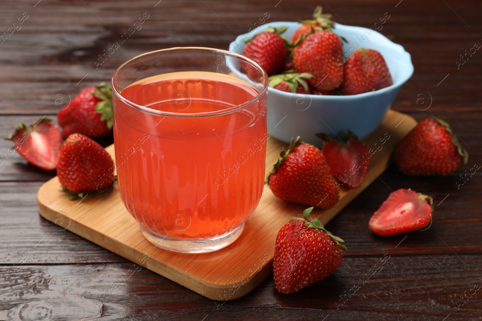 Photo of Tasty compot and strawberries on wooden table, closeup