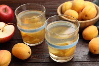 Photo of Tasty compot and fruits on wooden table, closeup