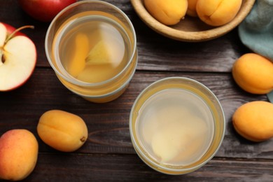Photo of Tasty compot and fruits on wooden table, flat lay