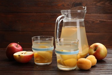 Photo of Tasty compot and fruits on wooden table