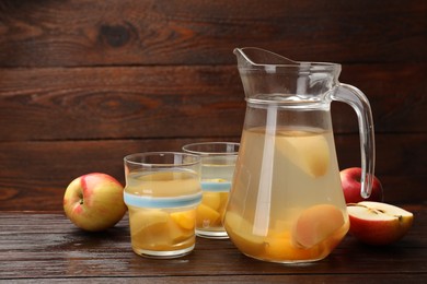 Photo of Tasty compot and fruits on wooden table. Space for text