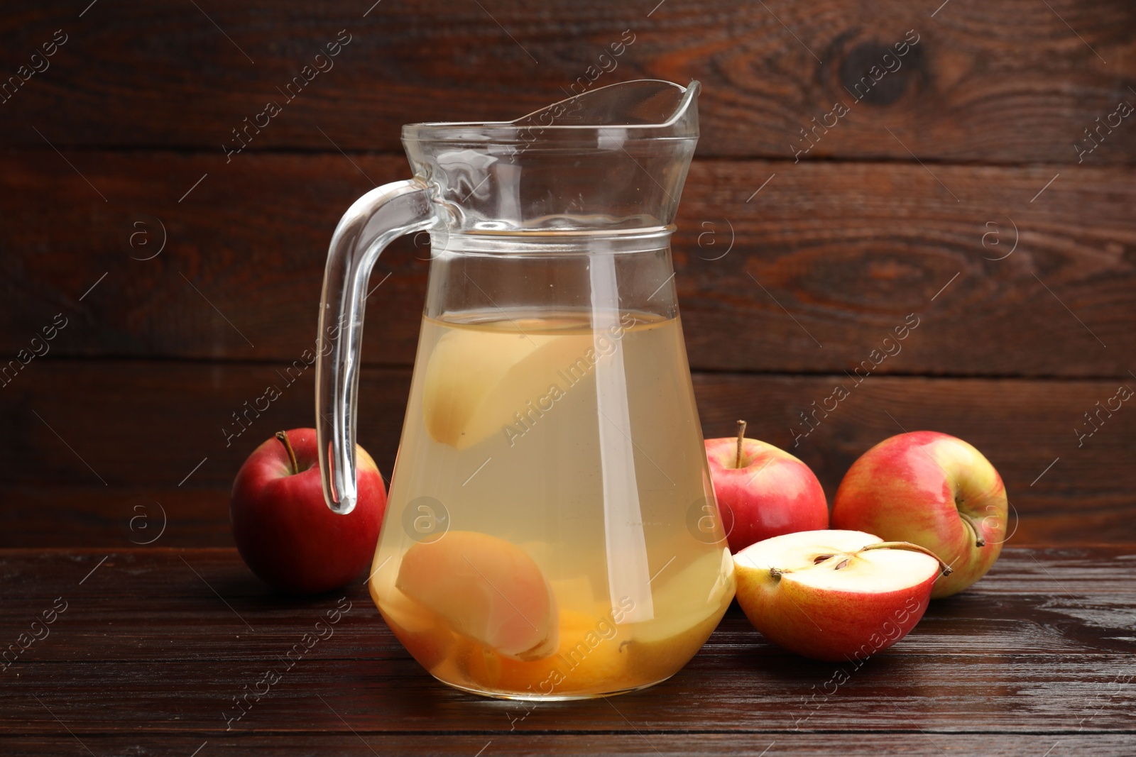 Photo of Tasty compot with apples on wooden table