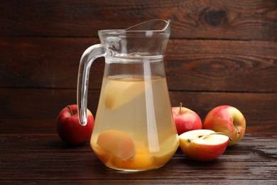 Photo of Tasty compot with apples on wooden table