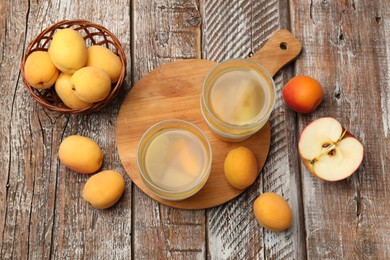 Photo of Tasty compot and fruits on wooden table, flat lay