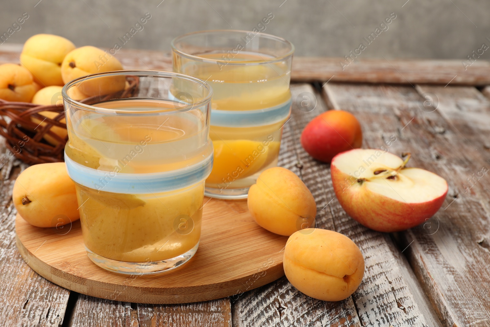 Photo of Tasty compot and fruits on wooden table, closeup