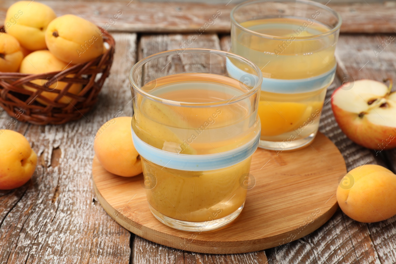 Photo of Tasty compot and fruits on wooden table, closeup
