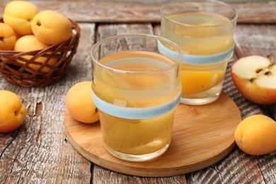 Photo of Tasty compot and fruits on wooden table, closeup
